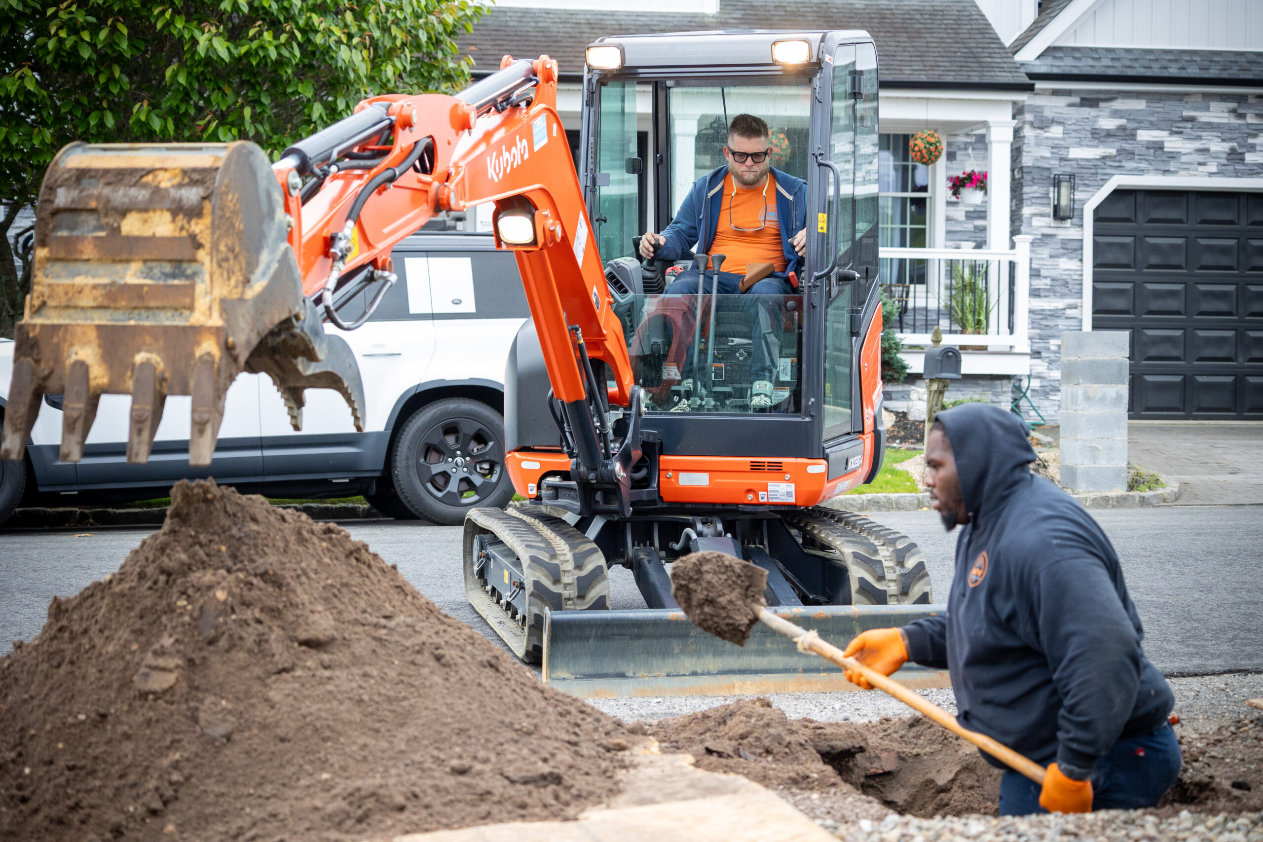 Construction workers with backhoe digging
